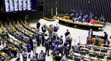 Imagem do plenário da Câmara, com deputados e deputadas em pé, e outros sentados