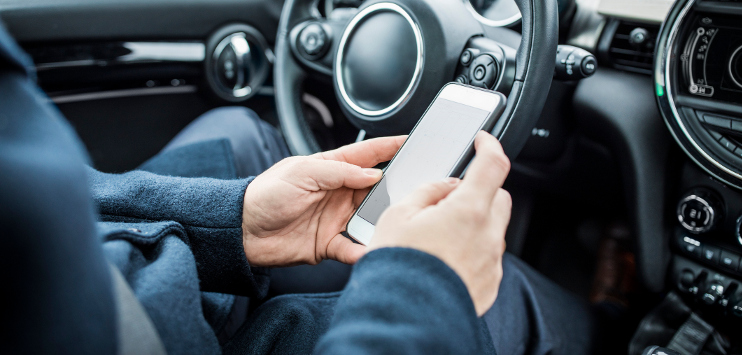 Fotografia de um passageiro utilizando um celular dentro de um carro