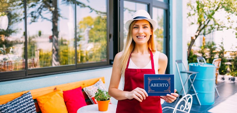 Imagem de uma mulher abrindo um estabelecimento comercial