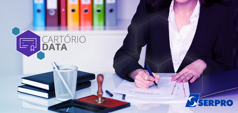 Imagem destaca área de trabalho com carimbos em cima da mesa indicando ambiente de um cartório