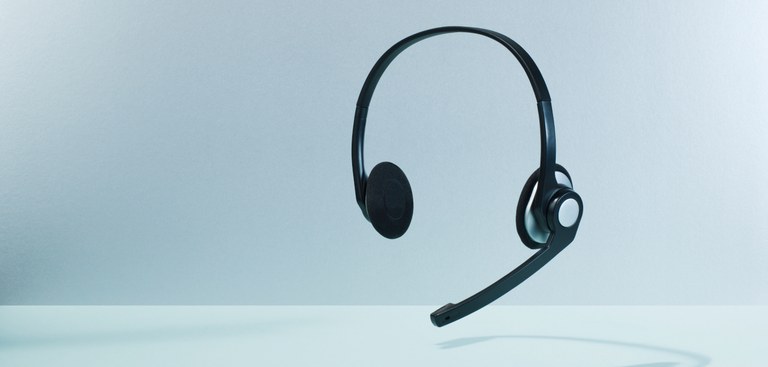Um headphone é exibido flutuando em frente ao fundo com degradê azul claro Um headphone é exibido flutuando em frente ao fundo com degradê azul claro