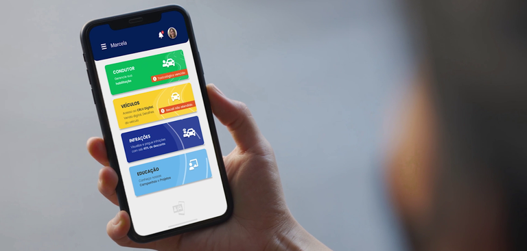 Homem segura celular que exibe o app CDT na tela Homem segura celular que exibe o app CDT na tela