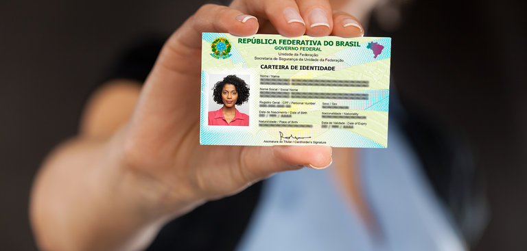 Close de uma mão segurando a nova Carteira de Identidade Nacional (CIN)