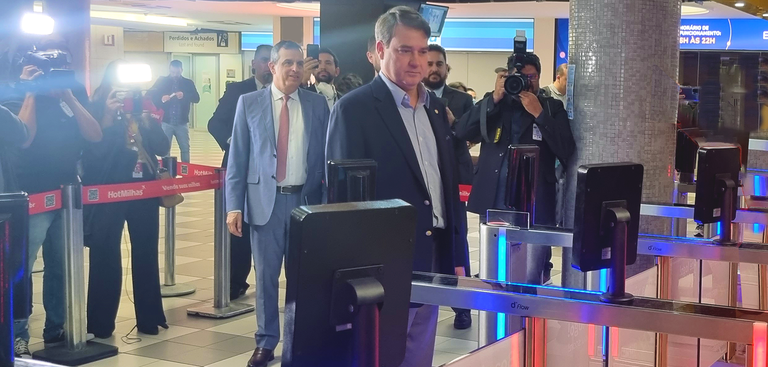 Presidente Gileno faz reconhecimento facial no aeroporto de Congonhas. Ao fundo, segurança do aeroporto e fotógrafos