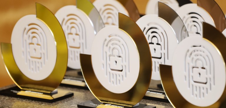 Close na mesa dos troféus entregues aos vencedores do Prêmio Serpro de Privacidade e Proteçãoo de Dados