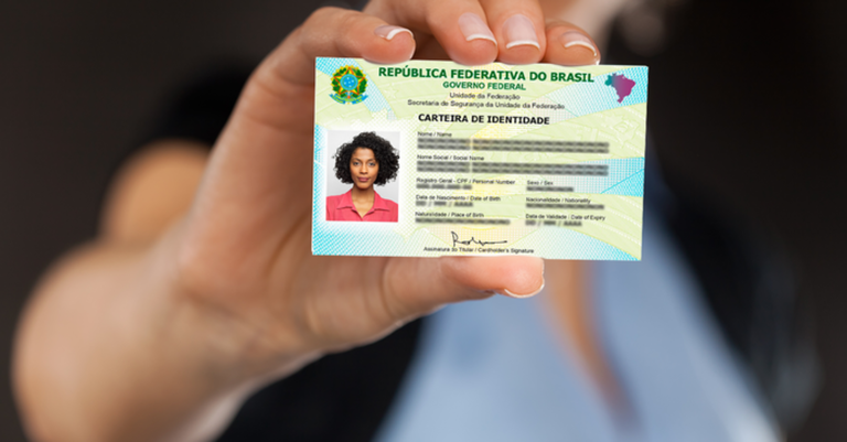 Imagem de uma mão de mulher segurando a versão física da nova Carteira de Identidade Nacional