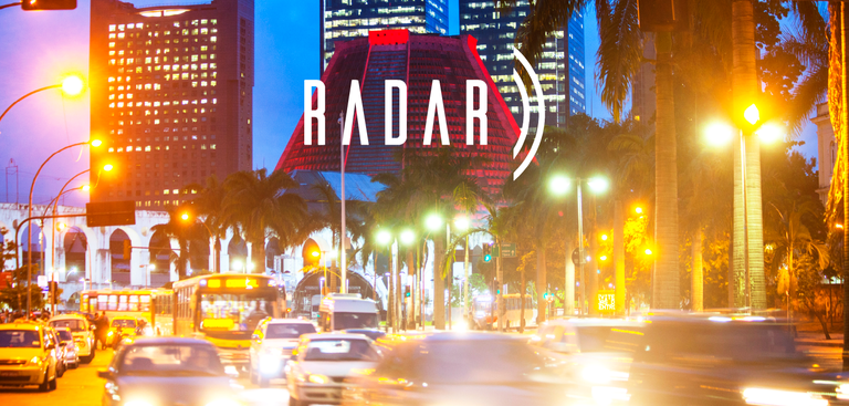 Fotografia noturna do bairro da Lapa, na cidade do Rio de Janeiro. Sobre a imagem está aplicada a marca do Radar