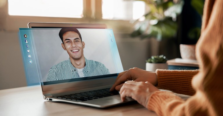 jovem mulher faz chamada de vídeo para homem que sorri.jpg