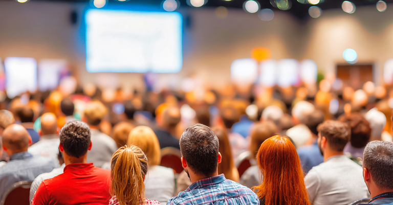Pessoas em um auditório assistindo a uma palestra