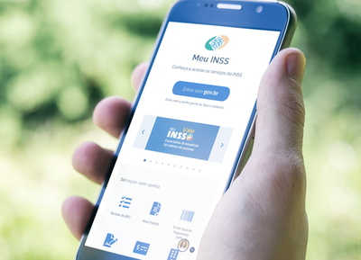 Mão segurando celular com aplicativo Meu Inss.png