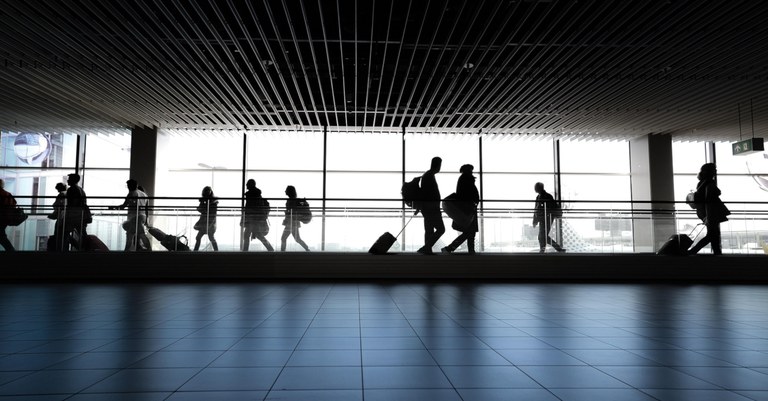 Pessoas no contra luz em esteira de aeroporto